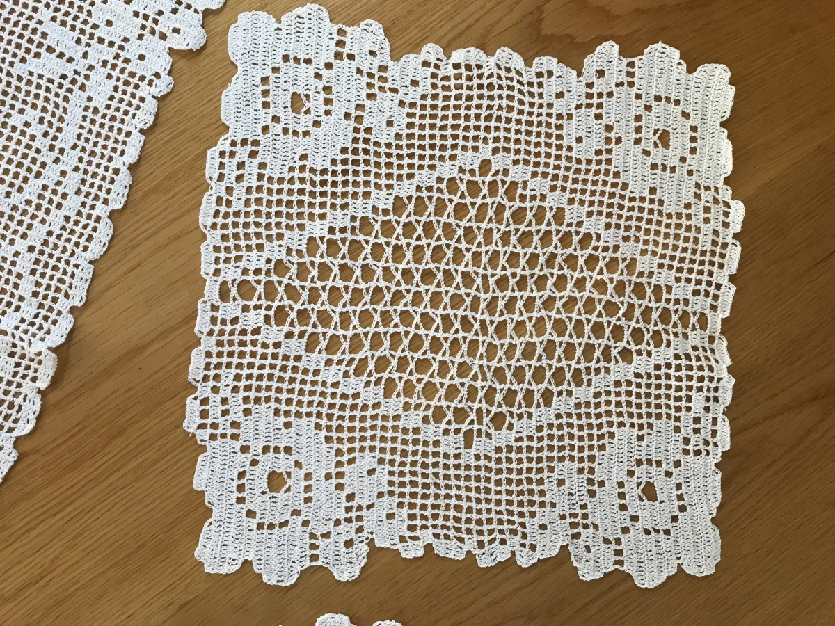 Two real filet crochet doilies showing open mesh, filled blocks, borders, and a non-rectangular center treatment