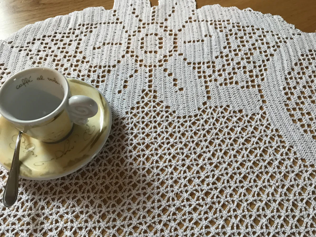 A real filet crochet textile combining conventional filled blocks with a more decorative net section